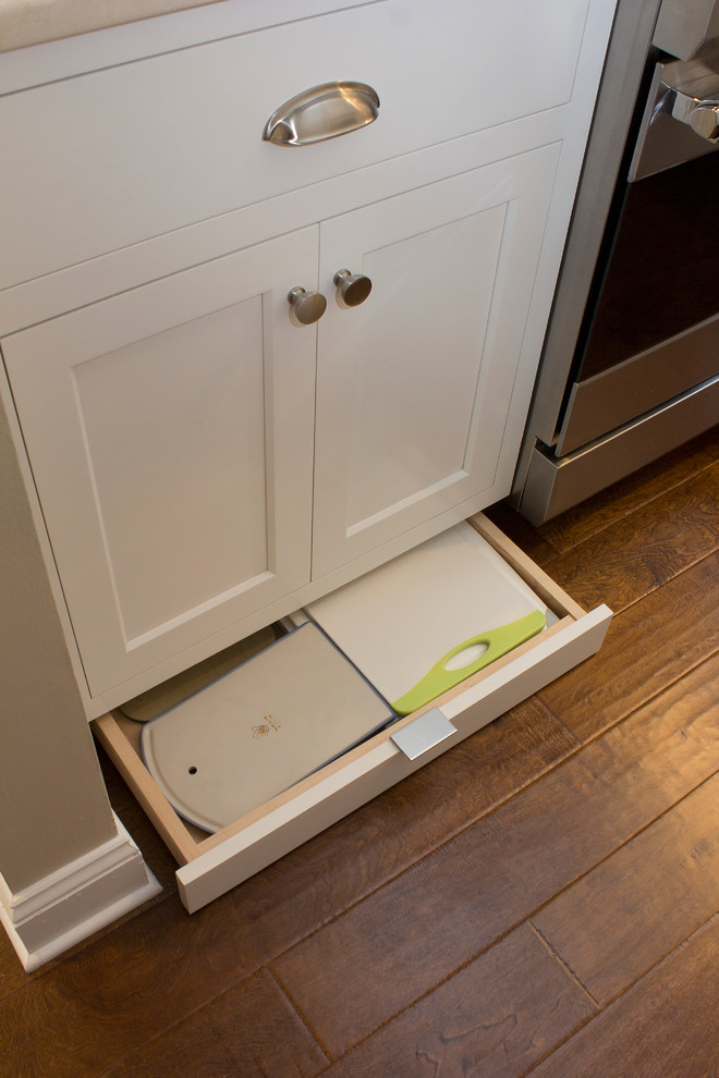 Example of a small transitional u-shaped dark wood floor and brown floor eat-in kitchen design in Raleigh with an undermount sink, recessed-panel cabinets, white cabinets, quartz countertops, white backsplash, subway tile backsplash, stainless steel appliances, no island and beige countertops