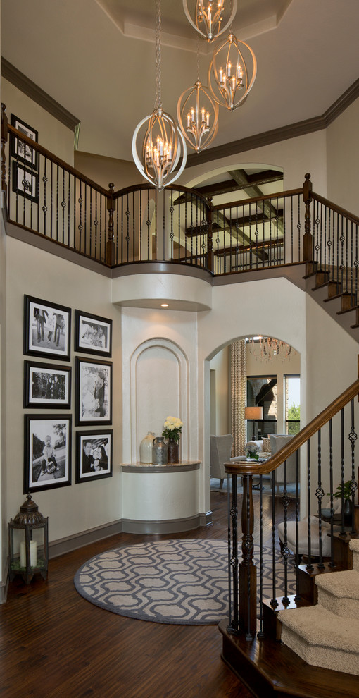 Inspiration for a large mediterranean foyer in Austin with beige walls and dark hardwood floors.