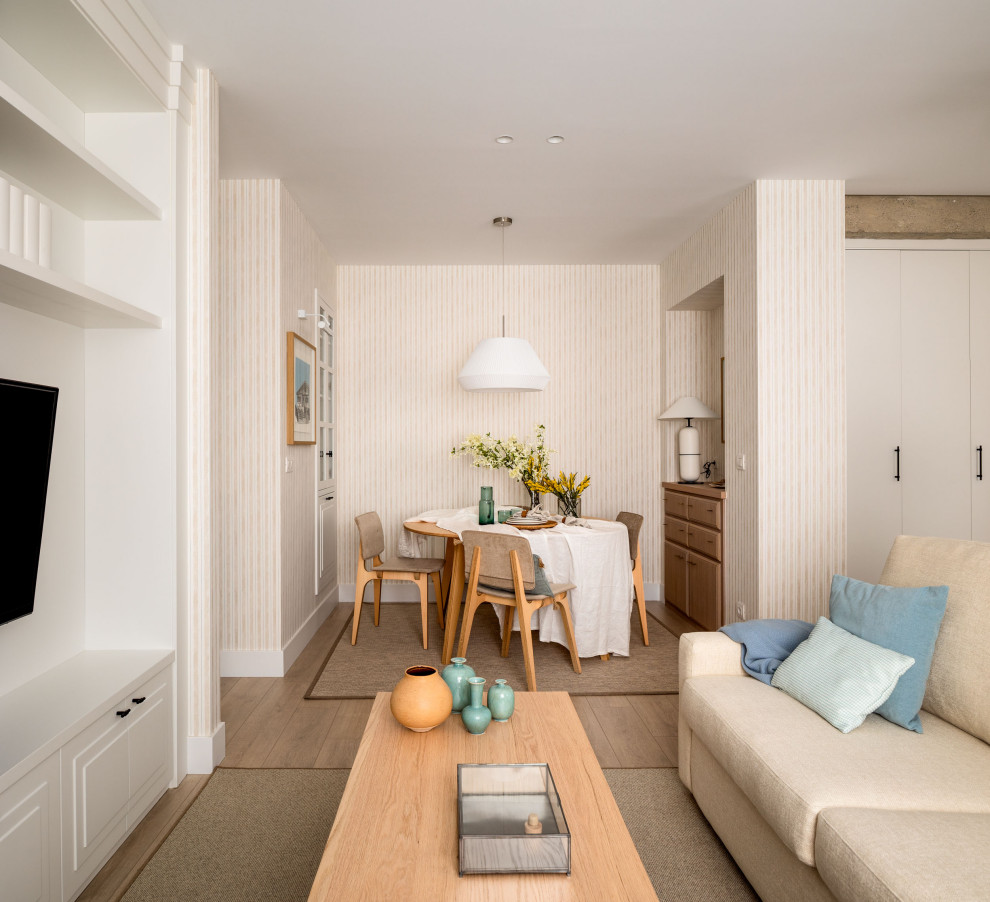 Diseño de comedor costero de tamaño medio abierto sin chimenea con paredes beige, suelo laminado, papel pintado y alfombra