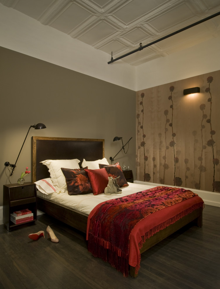 This is an example of an industrial bedroom in New York with multi-coloured walls and dark hardwood floors.