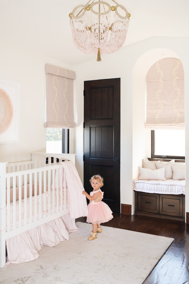 Mid-sized beach style nursery in Los Angeles with white walls, dark hardwood floors, brown floor and vaulted for girls.