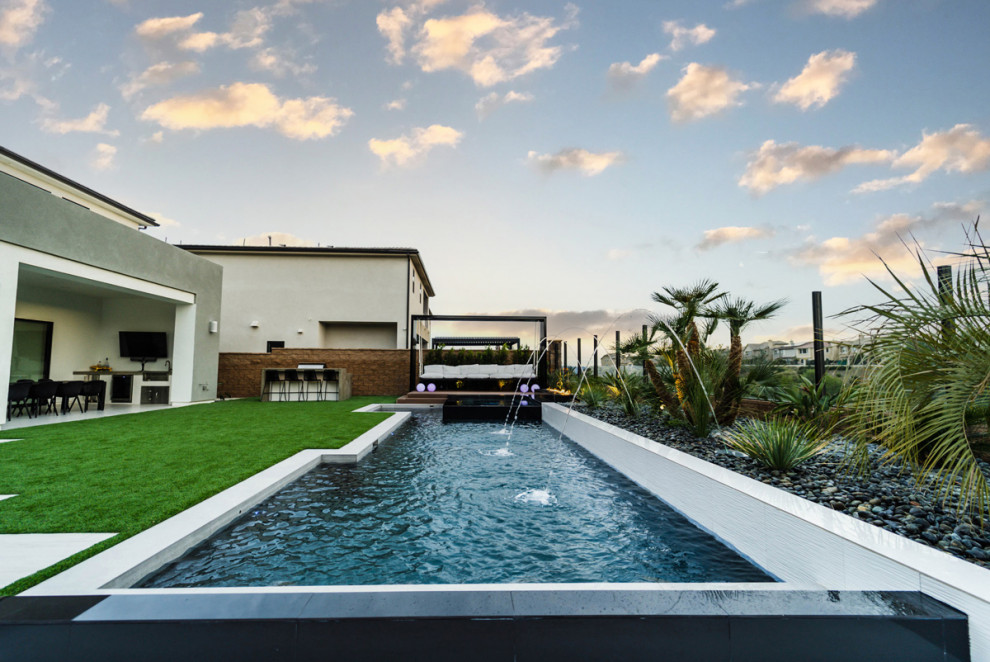 Idee per una piscina moderna a "L" di medie dimensioni e dietro casa con piastrelle