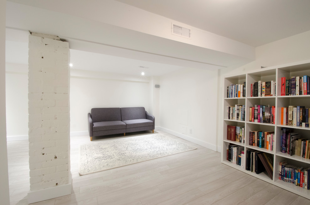 Example of a mid-sized transitional look-out laminate floor and beige floor basement design in Toronto with white walls
