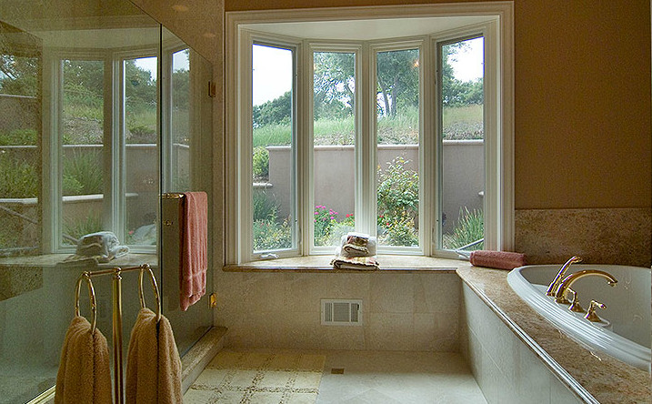 Example of a mid-sized transitional master brown tile and stone slab ceramic tile and beige floor corner shower design with beige walls, raised-panel cabinets, white cabinets, a two-piece toilet, an undermount sink, granite countertops and a hinged shower door