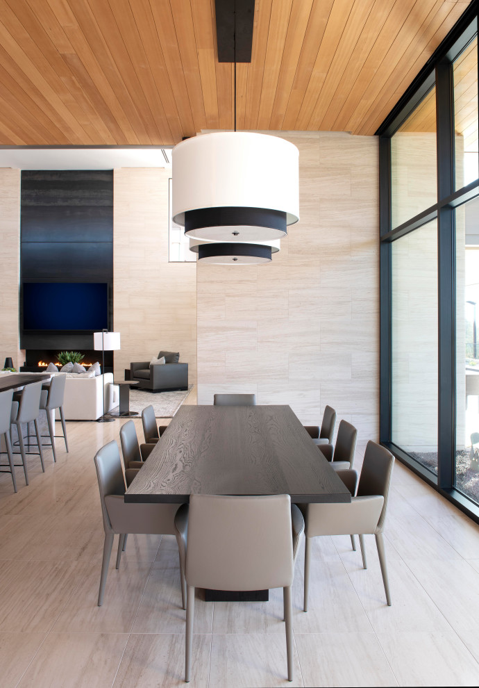 Immagine di una sala da pranzo aperta verso il soggiorno contemporanea con pavimento in pietra calcarea e soffitto in legno