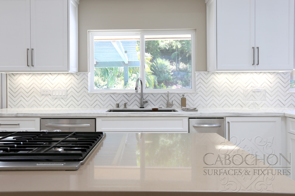 Mid-sized transitional l-shaped limestone floor open concept kitchen photo in San Diego with an island, shaker cabinets, white cabinets, marble countertops, white backsplash, mosaic tile backsplash, stainless steel appliances, an undermount sink and beige walls