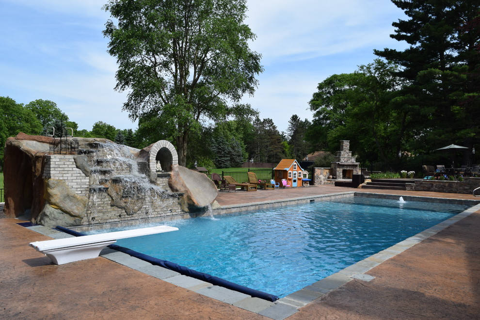 This is an example of a large contemporary backyard rectangular natural pool in Detroit with a water feature.