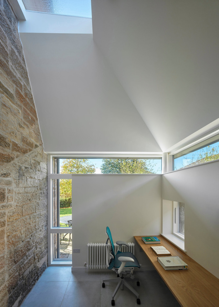 Пример оригинального дизайна: маленькое рабочее место в современном стиле с белыми стенами, полом из керамогранита, встроенным рабочим столом, серым полом и сводчатым потолком для на участке и в саду