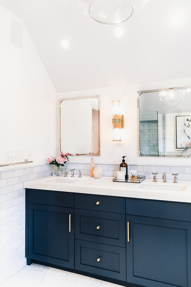 This is an example of a mid-sized transitional master bathroom in Baltimore with recessed-panel cabinets, blue cabinets, a japanese tub, a corner shower, a one-piece toilet, blue tile, marble, white walls, mosaic tile floors, a drop-in sink, marble benchtops, blue floor and a hinged shower door.