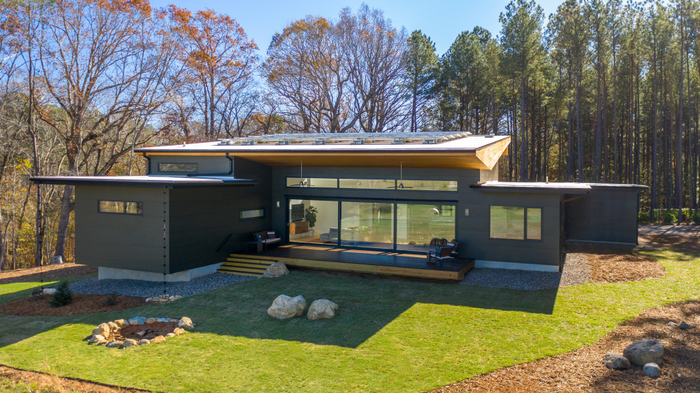 This is an example of a mid-sized modern one-storey grey house exterior in Raleigh with mixed siding and a white roof.