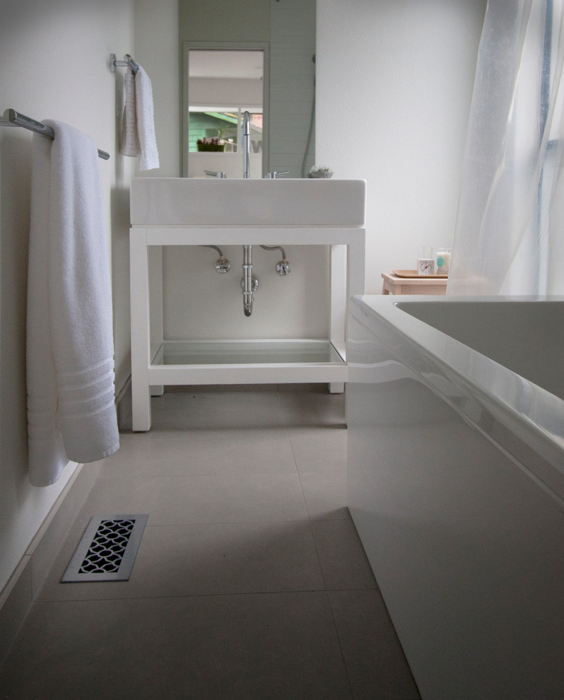 Example of a minimalist 3/4 freestanding bathtub design in Portland with a one-piece toilet, white walls, a console sink and quartz countertops