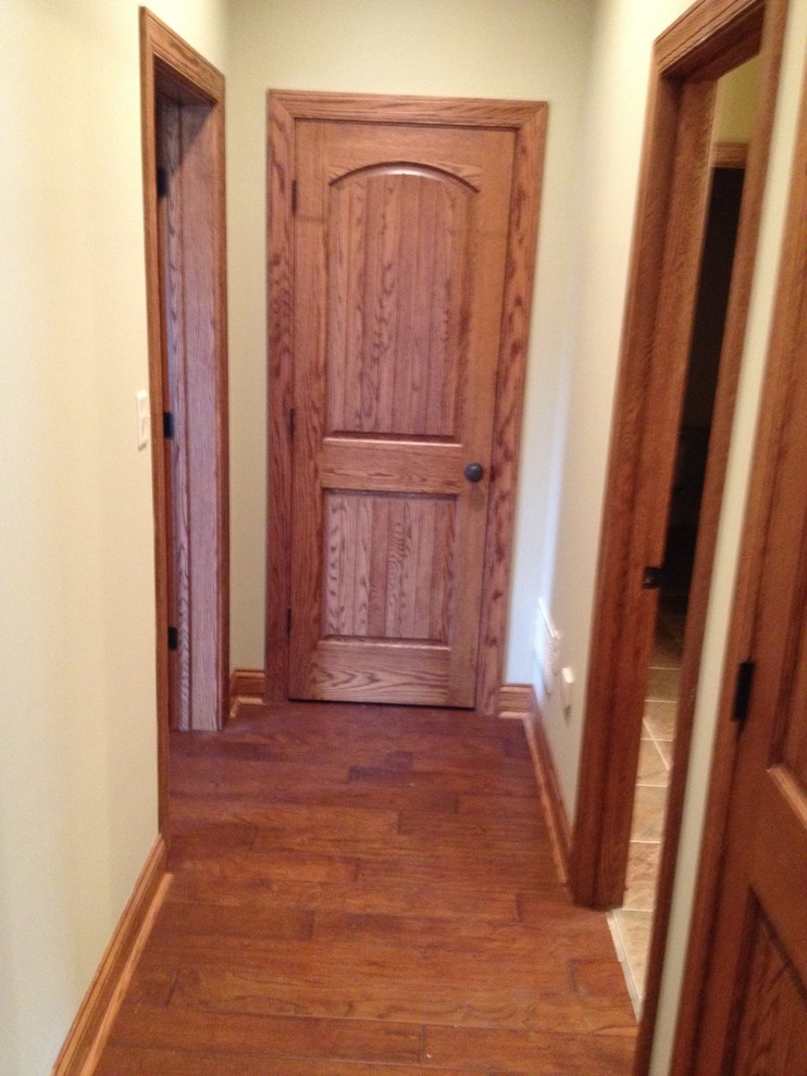 Mid-sized medium tone wood floor hallway photo with beige walls