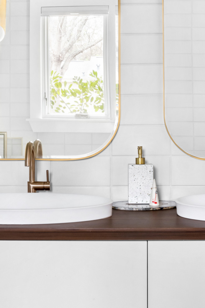 Bild på ett mellanstort funkis vit vitt badrum med dusch, med släta luckor, skåp i ljust trä, ett badkar med tassar, en dusch/badkar-kombination, en bidé, blå kakel, kakelplattor, vita väggar, klinkergolv i keramik, ett väggmonterat handfat, bänkskiva i akrylsten, vitt golv och dusch med gångjärnsdörr