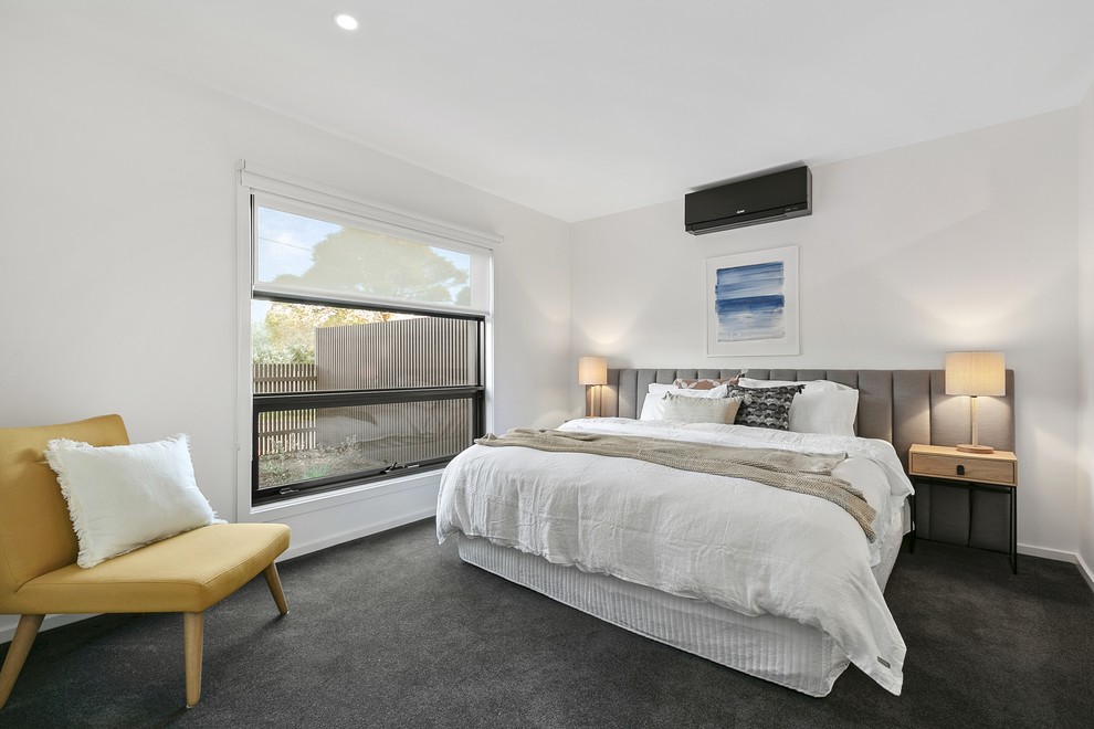 This is an example of a contemporary bedroom in Melbourne with white walls, carpet and black floor.
