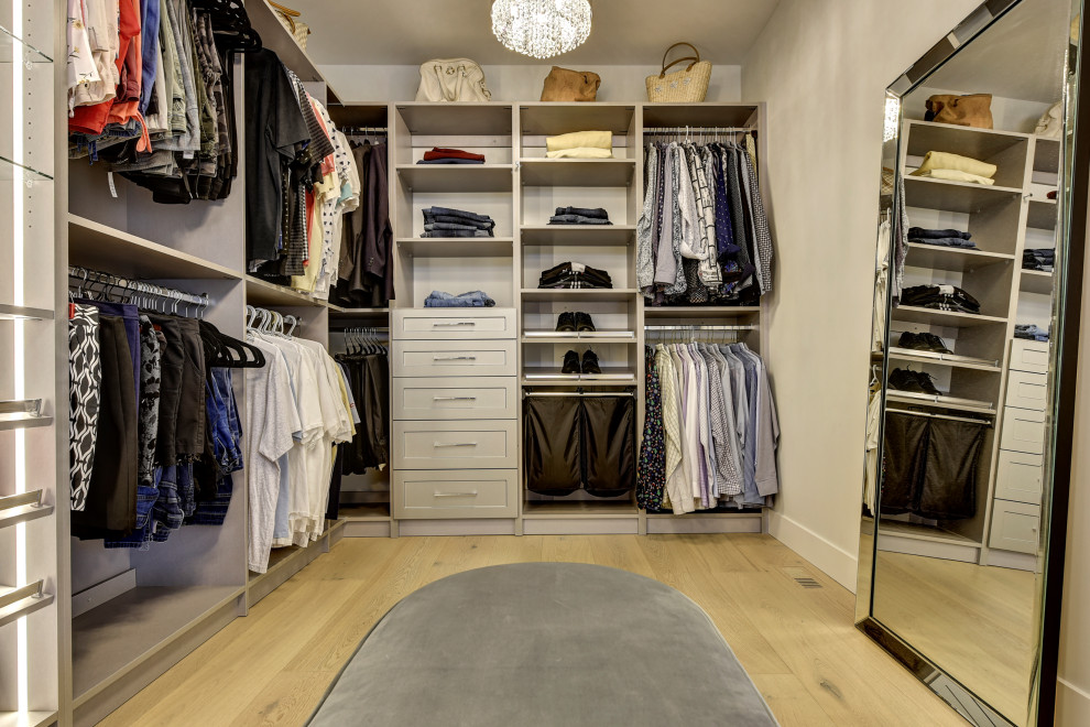 Diseño de armario vestidor unisex clásico renovado grande con armarios estilo shaker y suelo de madera clara