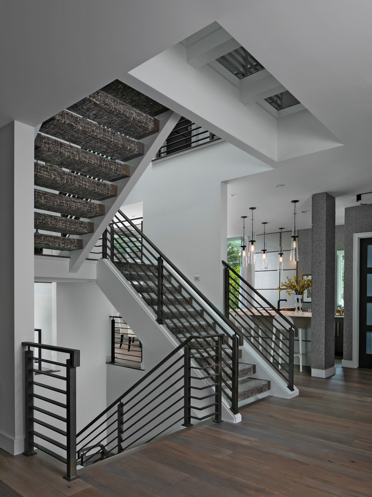 Photo of a contemporary u-shaped staircase in Detroit with open risers and cable railing.
