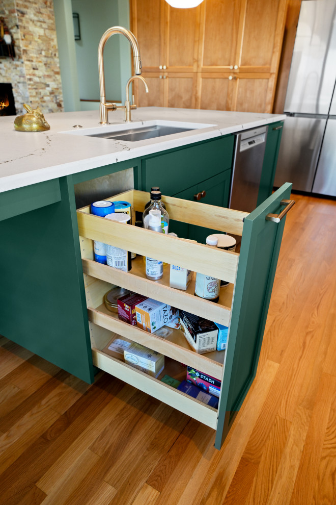 Example of a transitional l-shaped medium tone wood floor kitchen design with shaker cabinets, white backsplash, an island and white countertops