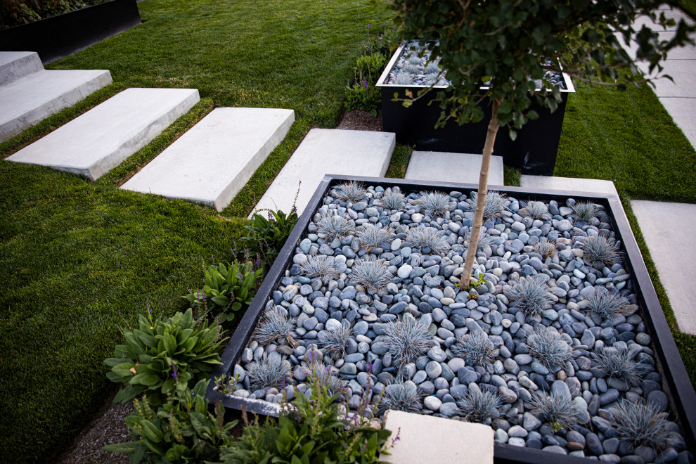 Idee per un giardino xeriscape moderno davanti casa con sassi di fiume