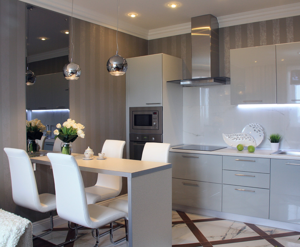 This is an example of a small contemporary single-wall open plan kitchen in Other with a drop-in sink, flat-panel cabinets, grey cabinets, laminate benchtops, white splashback, porcelain floors, a peninsula and stainless steel appliances.