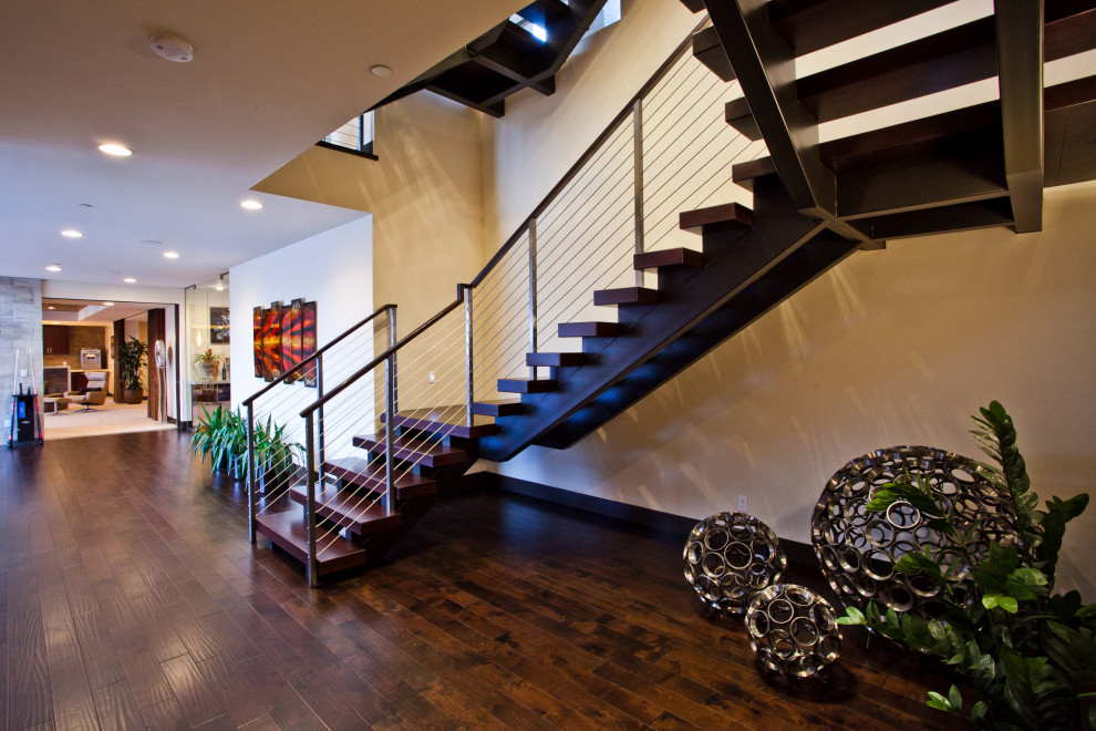 This is an example of a large contemporary wood floating staircase in Las Vegas with wood risers and mixed railing.