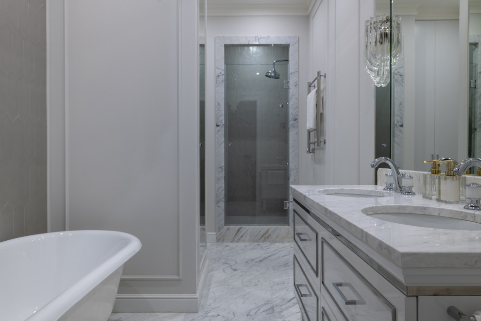 Inspiration for a mid-sized transitional 3/4 bathroom in Moscow with beaded inset cabinets, white cabinets, a claw-foot tub, an alcove shower, a wall-mount toilet, gray tile, porcelain tile, grey walls, marble floors, an undermount sink, marble benchtops, white floor, a hinged shower door, white benchtops, a niche, a double vanity and a freestanding vanity.