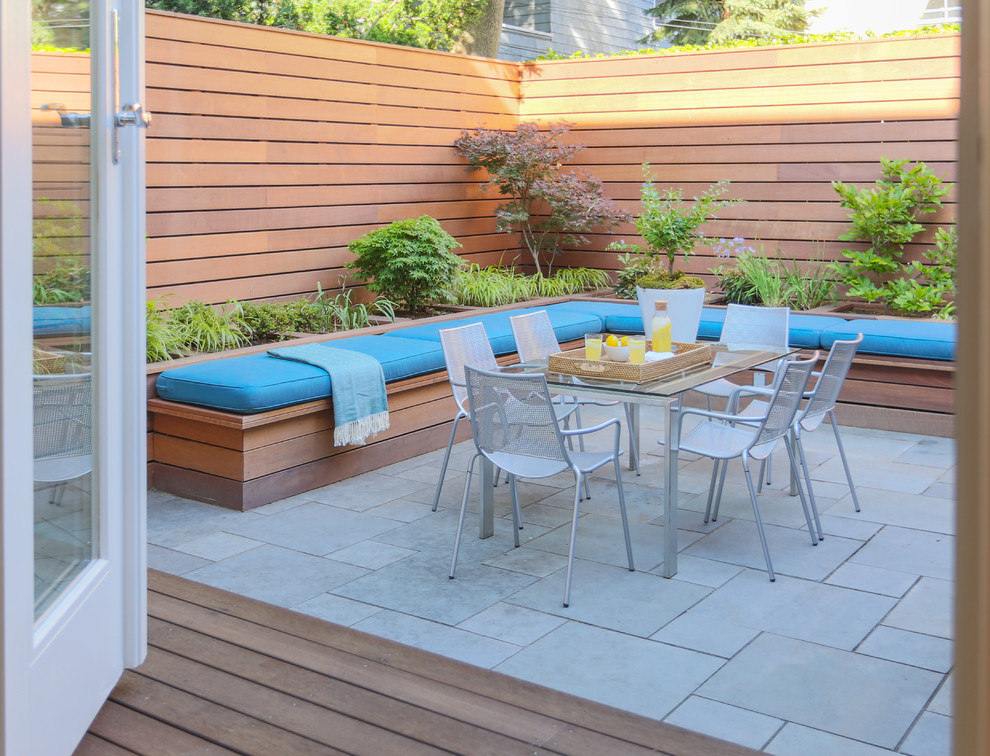 This is an example of a small contemporary backyard patio in Boston with tile and no cover.