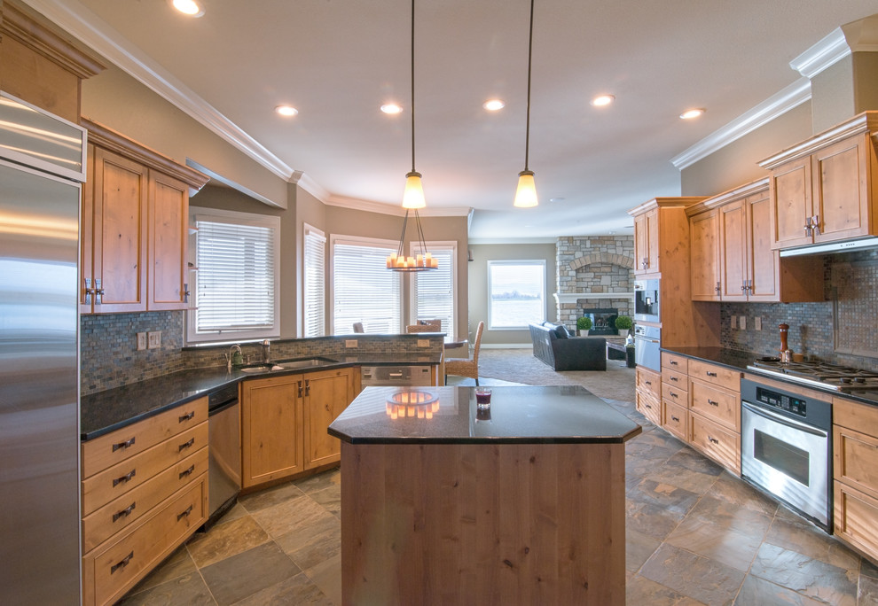 Inspiration for a large transitional slate floor eat-in kitchen remodel in Denver with a double-bowl sink, shaker cabinets, light wood cabinets, granite countertops, gray backsplash, stone tile backsplash, stainless steel appliances and an island