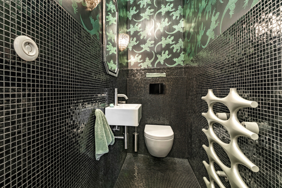 Photo of a small bohemian cloakroom in Munich with mosaic tiles, black walls, mosaic tile flooring, a wall-mounted sink, black floors, a floating vanity unit, wallpapered walls and a wall mounted toilet.