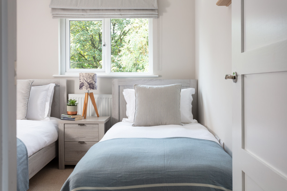 This is an example of a mid-sized scandinavian guest bedroom in Cornwall with grey walls, carpet, no fireplace and beige floor.
