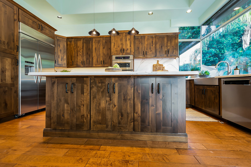 Large transitional u-shaped open concept kitchen photo in Phoenix with a farmhouse sink, shaker cabinets, dark wood cabinets, quartz countertops, white backsplash, quartz backsplash, stainless steel appliances, an island and white countertops