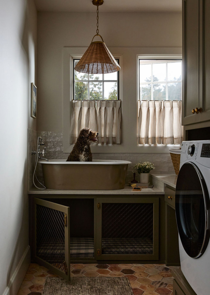 Dedicated laundry room - country l-shaped brown floor dedicated laundry room idea in Oklahoma City with an utility sink, recessed-panel cabinets, green cabinets, beige walls, a side-by-side washer/dryer and gray countertops