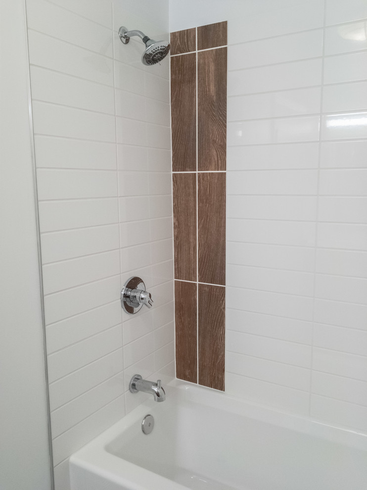 Inspiration for a small transitional bathroom in Raleigh with flat-panel cabinets, brown cabinets, an alcove tub, a shower/bathtub combo, a one-piece toilet, white tile, ceramic tile, white walls, porcelain floors, an integrated sink and solid surface benchtops.