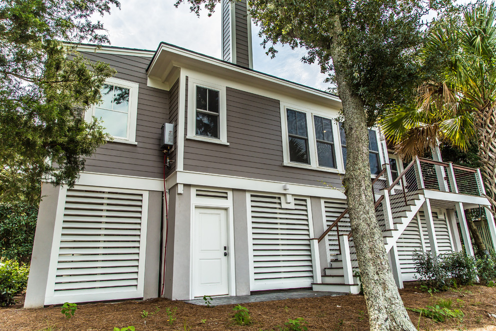 Photo of a large beach style three-storey grey exterior in Charleston with mixed siding and a gable roof.