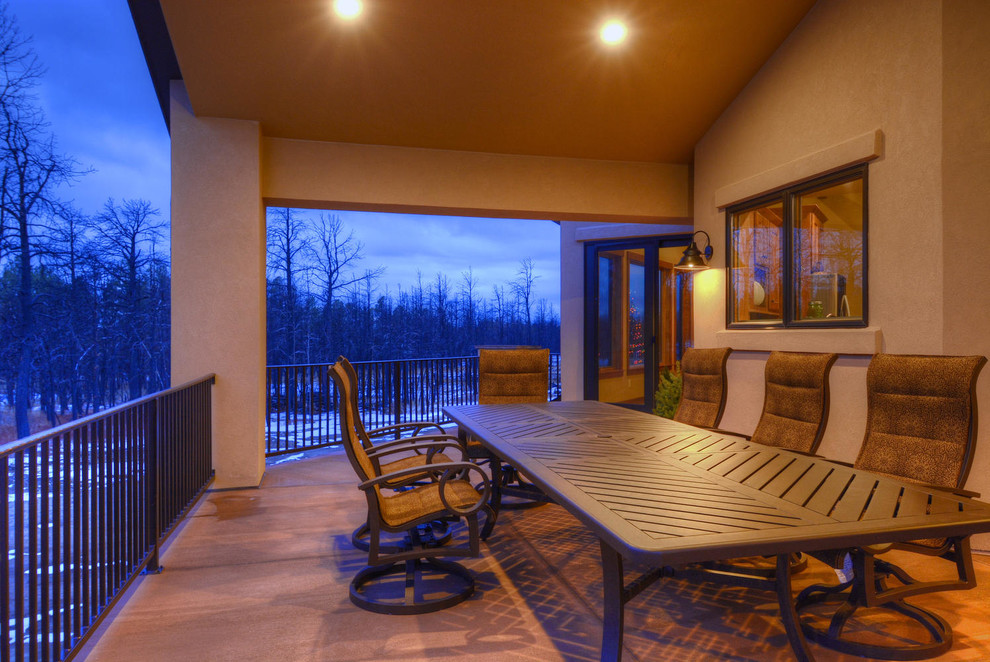 Example of a transitional backyard balcony deck design in Denver with a roof extension