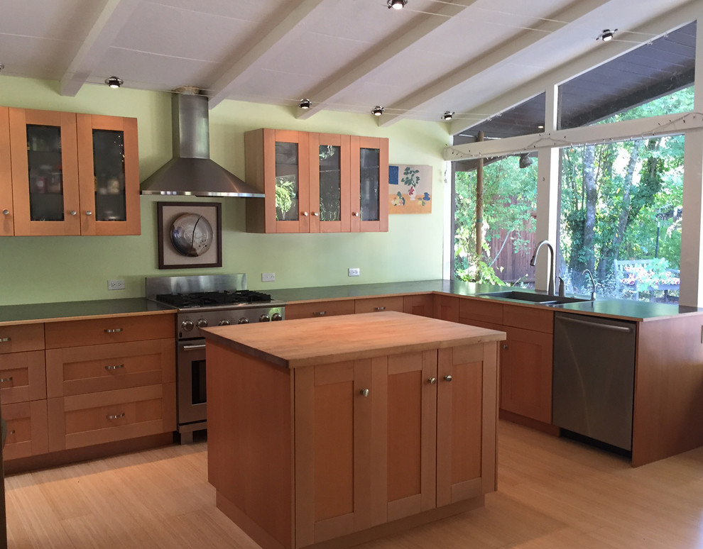Photo of a mid-sized midcentury l-shaped eat-in kitchen in San Francisco with a single-bowl sink, shaker cabinets, light wood cabinets, wood benchtops, stainless steel appliances, bamboo floors, with island and window splashback.
