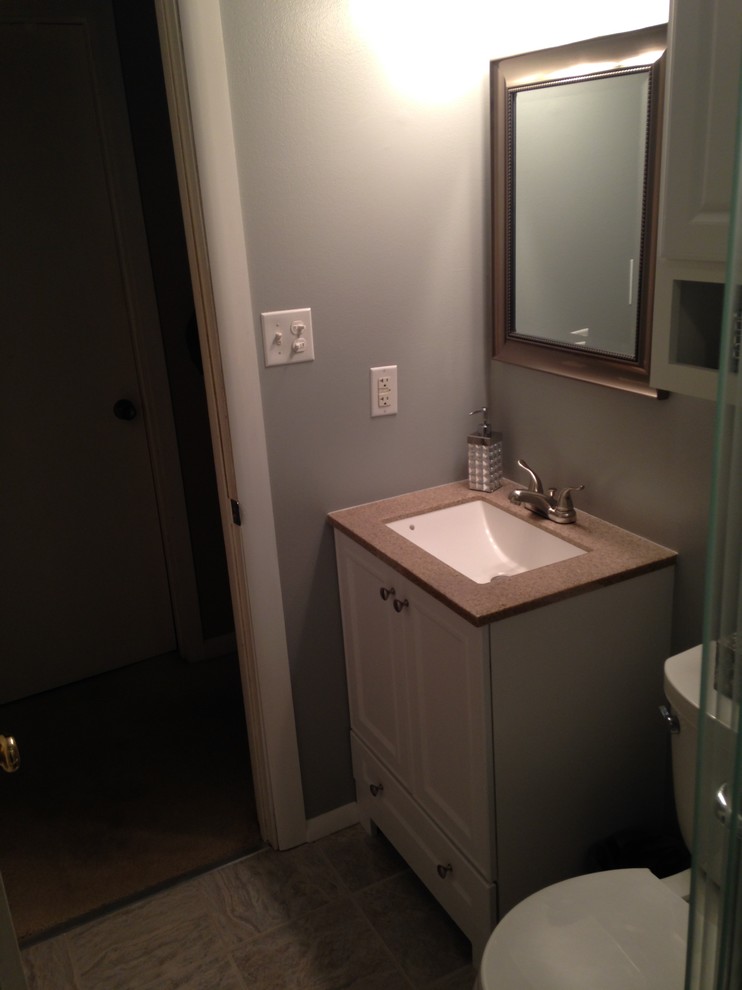 Mid-sized traditional bathroom in Chicago with an undermount sink, furniture-like cabinets, white cabinets, solid surface benchtops, an alcove tub, an alcove shower, a two-piece toilet, white tile, subway tile, grey walls and ceramic floors.