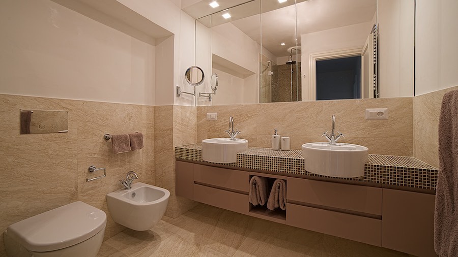 Design ideas for a mid-sized traditional 3/4 bathroom in Rome with flat-panel cabinets, purple cabinets, a corner shower, a two-piece toilet, beige tile, travertine, beige walls, travertine floors, a vessel sink, tile benchtops, beige floor, a hinged shower door and purple benchtops.