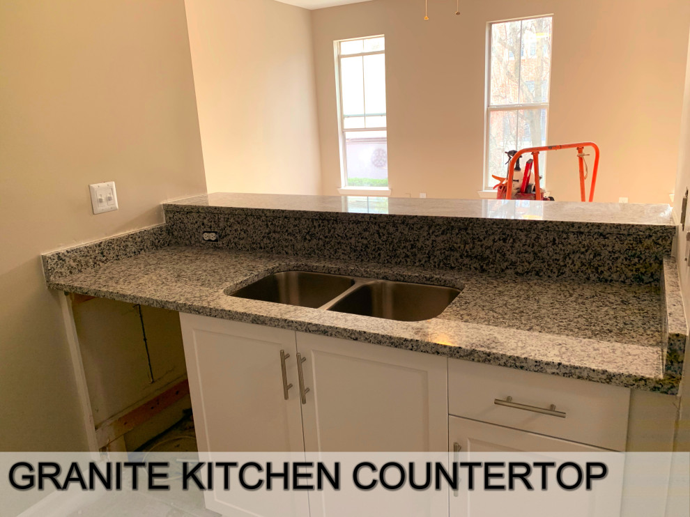 Photo of a mid-sized modern galley eat-in kitchen in Atlanta with beige cabinets, granite benchtops, a double-bowl sink, grey splashback, granite splashback, stainless steel appliances, with island and grey benchtop.