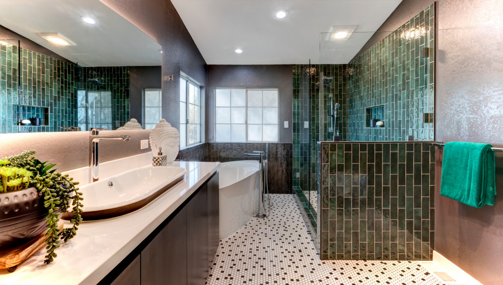 На фото: большая главная ванная комната в современном стиле с плоскими фасадами, темными деревянными фасадами, отдельно стоящей ванной, открытым душем, инсталляцией, зеленой плиткой, керамогранитной плиткой, коричневыми стенами, полом из мозаичной плитки, настольной раковиной, столешницей из искусственного кварца, разноцветным полом, душем с раздвижными дверями, белой столешницей, тумбой под одну раковину и встроенной тумбой