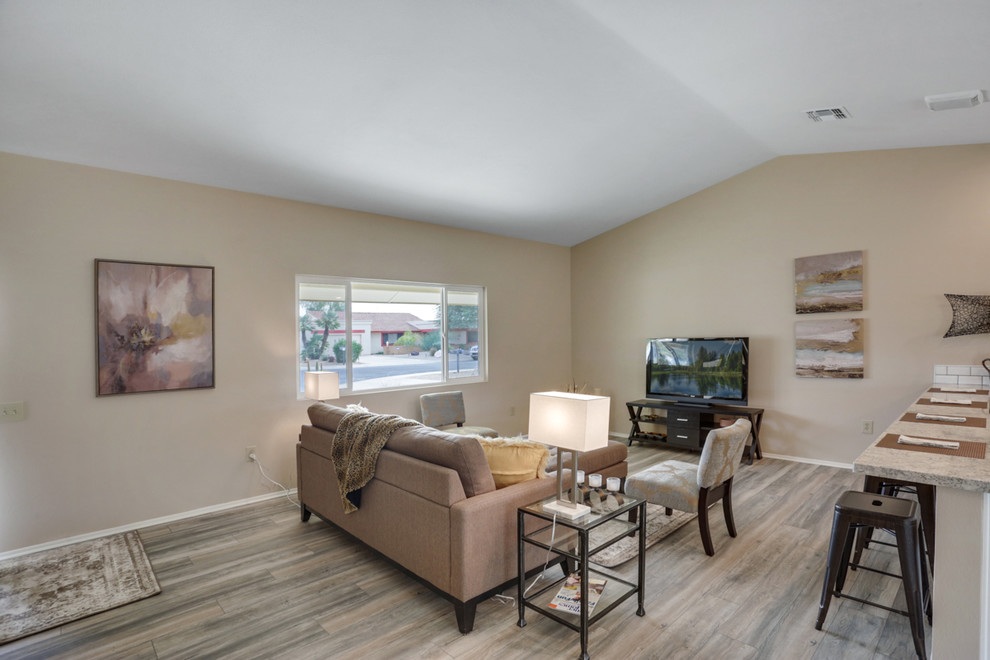 Mid-sized transitional open concept living room in Phoenix with beige walls, laminate floors, no fireplace, a freestanding tv and beige floor.
