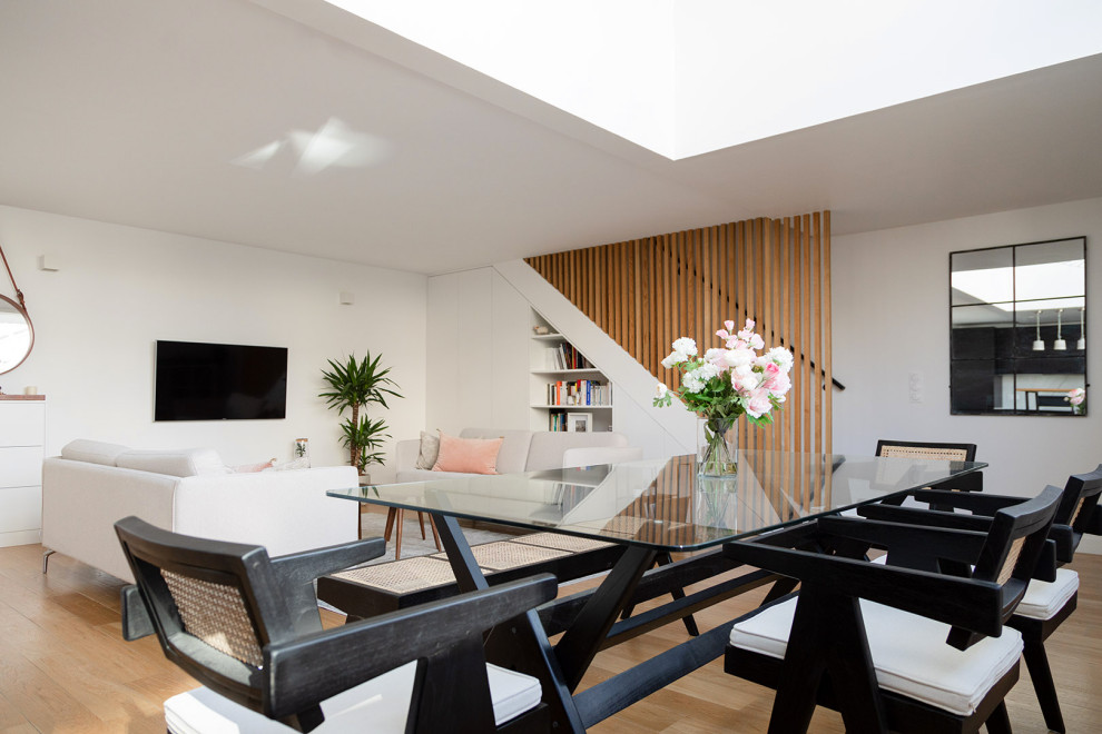 Стильный дизайн: гостиная-столовая среднего размера в современном стиле с белыми стенами, светлым паркетным полом и бежевым полом без камина - последний тренд
