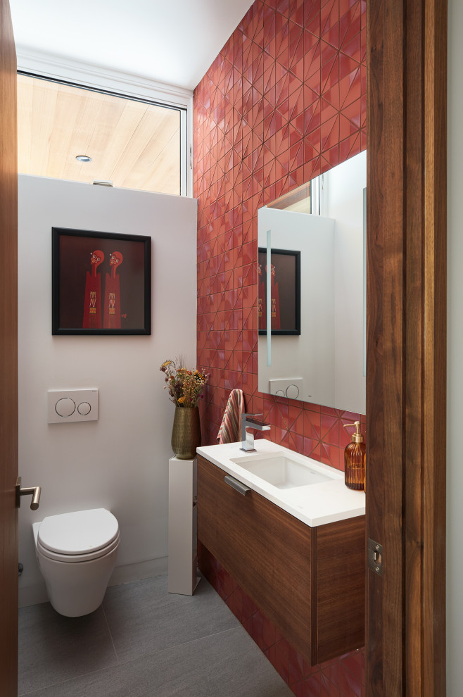 Immagine di un bagno di servizio moderno con ante lisce, ante in legno scuro, piastrelle rosse, pareti bianche, lavabo sottopiano, pavimento grigio, top bianco e mobile bagno sospeso