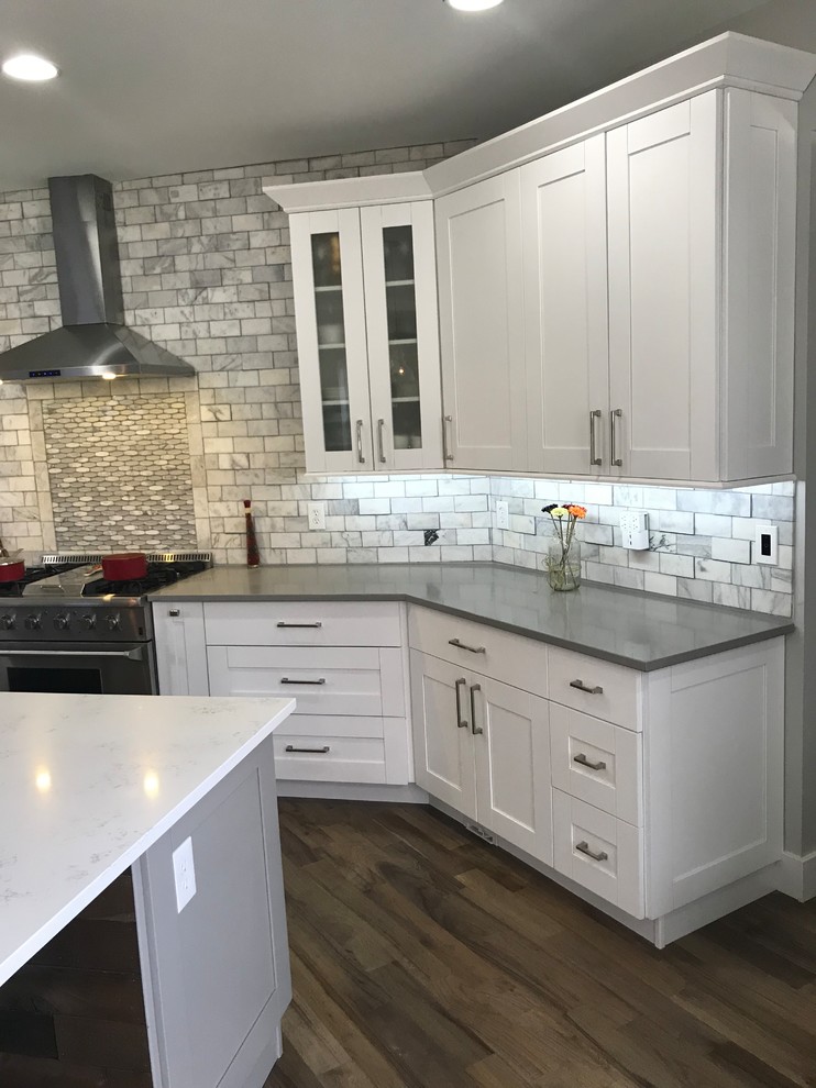 Eat-in kitchen - large transitional single-wall light wood floor and gray floor eat-in kitchen idea in Atlanta with a farmhouse sink, shaker cabinets, white cabinets, quartzite countertops, white backsplash, marble backsplash, stainless steel appliances, an island and white countertops