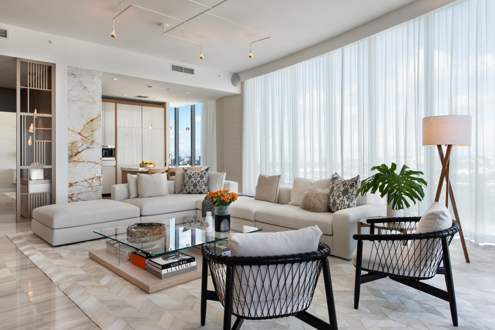 This is an example of a contemporary open concept living room in Miami with white walls and grey floor.