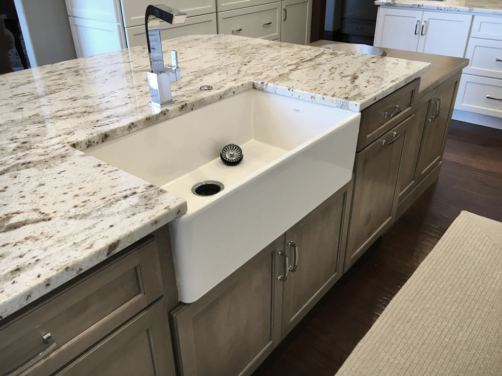 Large transitional l-shaped dark wood floor and brown floor eat-in kitchen photo with a farmhouse sink, recessed-panel cabinets, light wood cabinets, granite countertops, white backsplash, ceramic backsplash, stainless steel appliances and an island