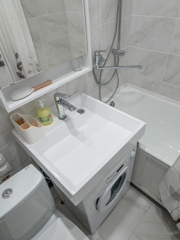 Стильный дизайн: маленькая серо-белая ванная комната со стиральной машиной с унитазом-моноблоком, белой плиткой, керамической плиткой, белыми стенами, полом из керамической плитки и белым полом для на участке и в саду - последний тренд