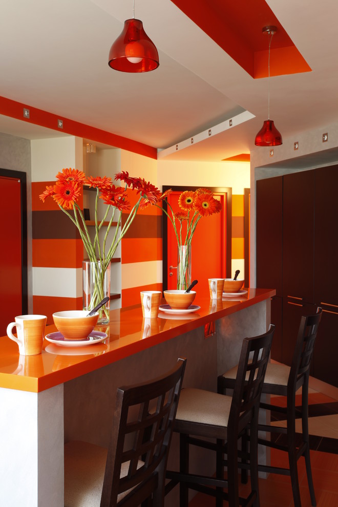 Design ideas for a contemporary l-shaped eat-in kitchen in Moscow with orange cabinets, solid surface benchtops, an integrated sink, mosaic tile splashback and ceramic floors.