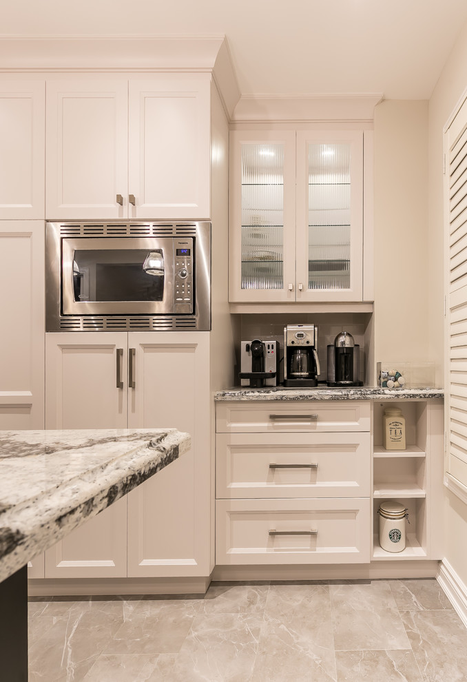 Example of a large transitional gray floor enclosed kitchen design in Toronto with an undermount sink, recessed-panel cabinets, white cabinets, quartz countertops, white backsplash, ceramic backsplash, stainless steel appliances and an island