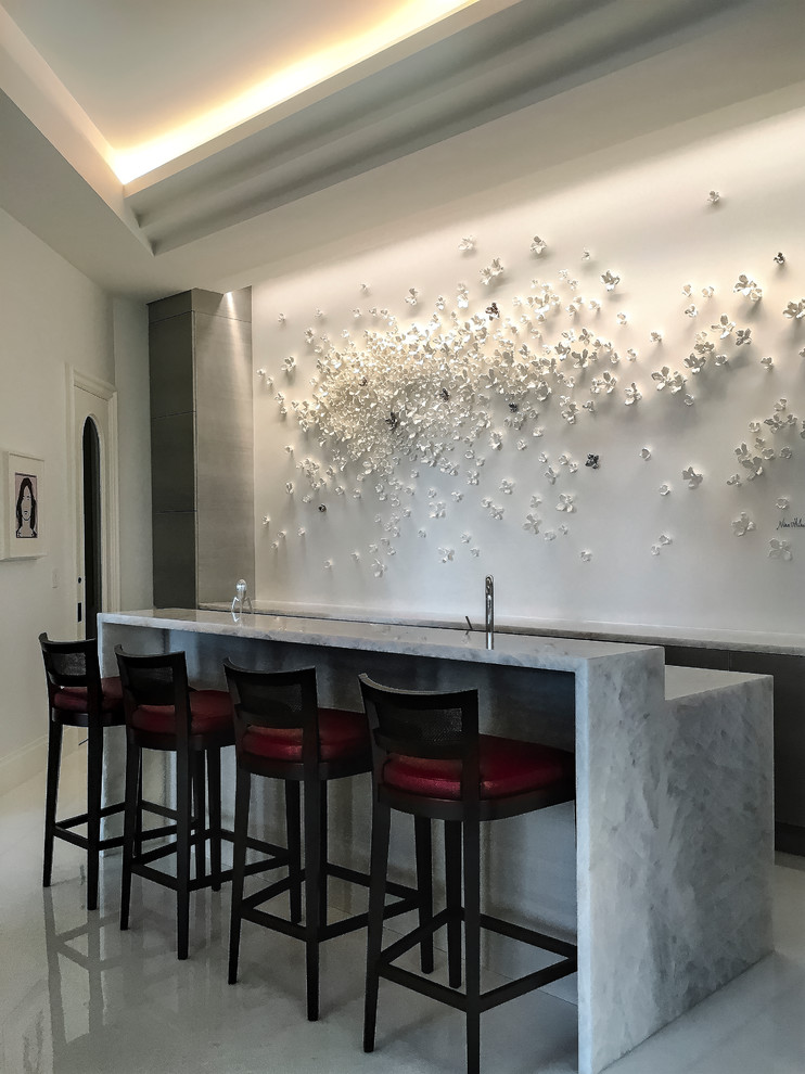 Design ideas for a mid-sized contemporary seated home bar in Miami with white splashback, quartzite benchtops, marble floors, white floor and white benchtop.