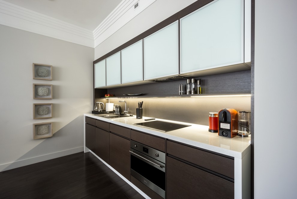 This is an example of a contemporary single-wall kitchen in Moscow with a drop-in sink, flat-panel cabinets, dark wood cabinets, stainless steel appliances and no island.